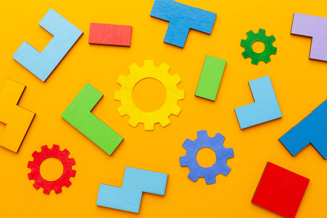 Colorful wooden blocks and gears arranged on a bright yellow background, representing child psychology, early childhood development, and creative thinking MentalHealthEbooks